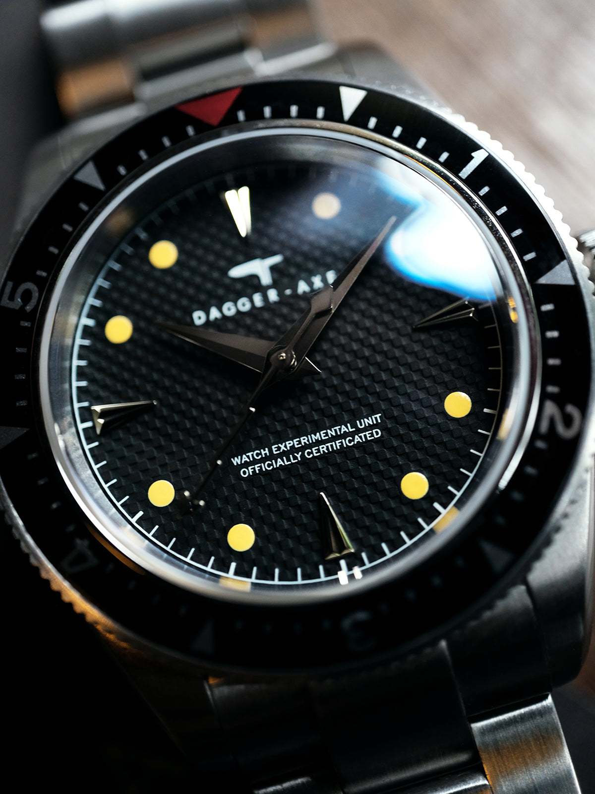 Obsidian watch close-up showing black dial and luminous hour markers